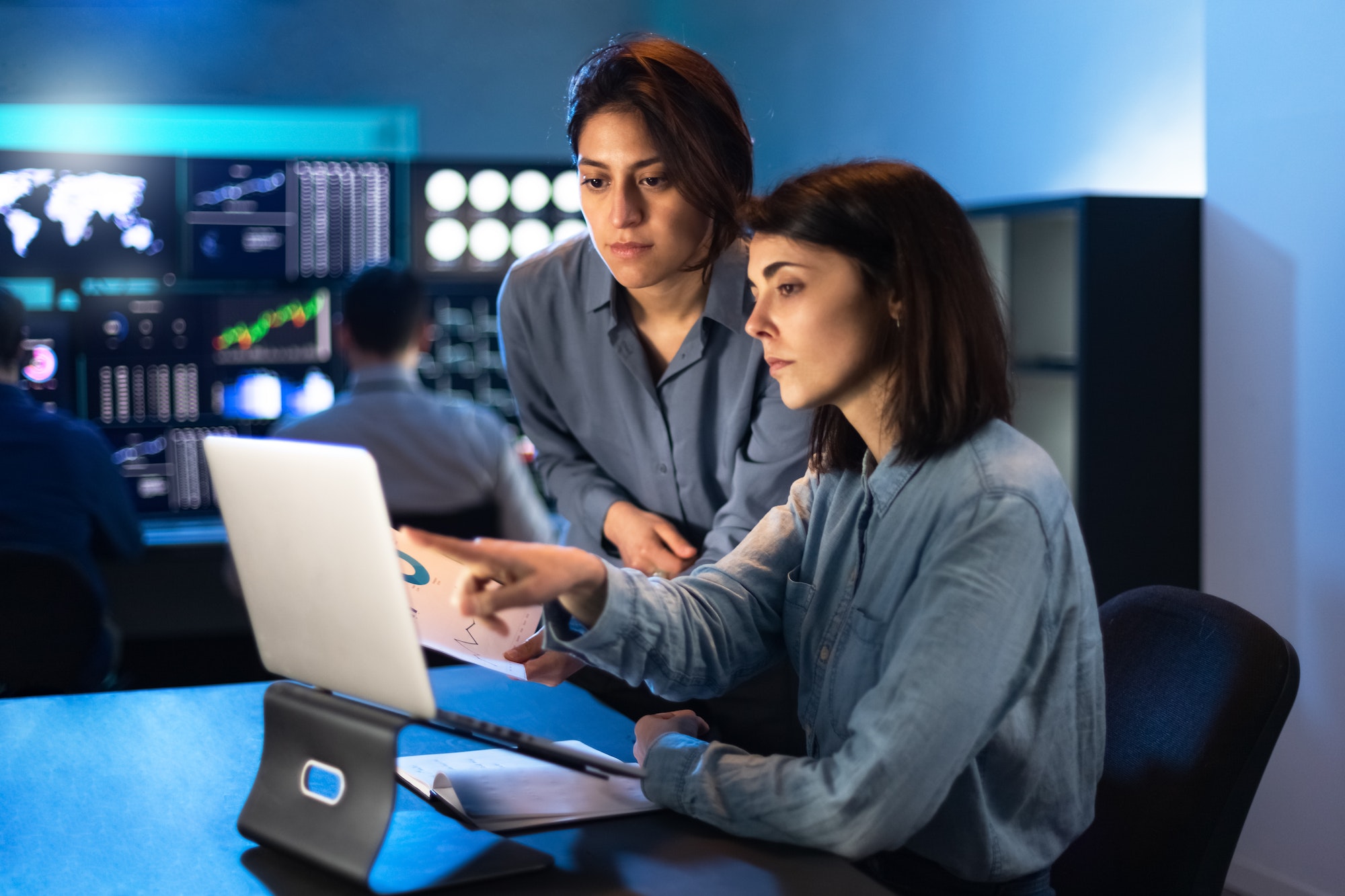 Female financial analyst coworkers comment on graphs and investment risks. Trading and stock market.